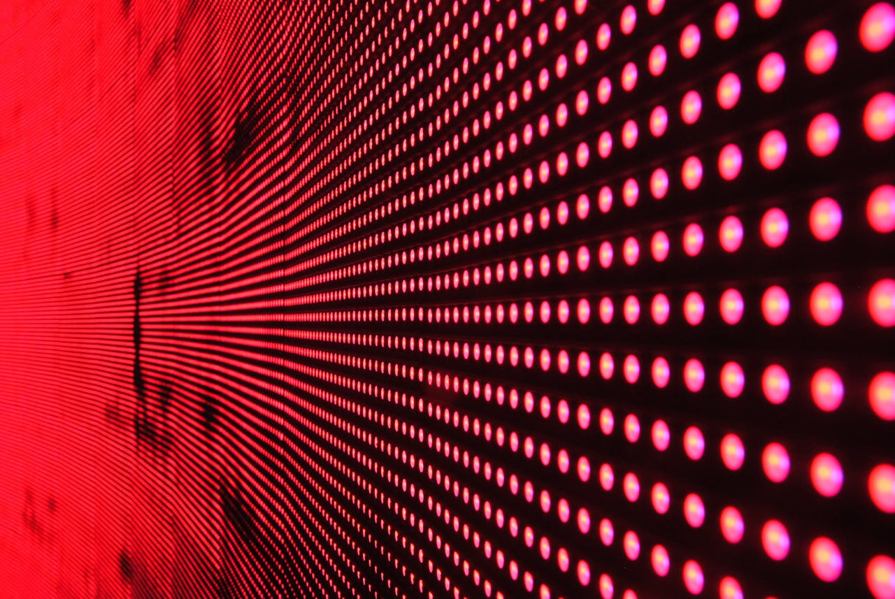why-choose-us Vibrant abstract pattern of illuminated red LED lights forming a dynamic design.